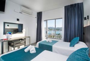Cette chambre comprend 2 lits et une fenêtre. dans l'établissement Hotel Base - Adults Only, à Sant Antoni de Portmany