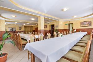 comedor grande con mesa larga y sillas en Hotel Stary Ratusz, en Kostomłoty
