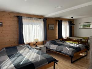 a bedroom with two beds and a desk in it at Alexandar studio apartman in Mokra Gora