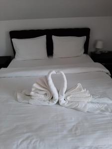 Dos cisnes haciendo un corazón en una cama en Casa Adrian, en Hîrşova