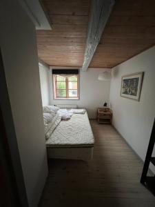 フレデンスボーにあるJulieanehåbの小さなベッドルーム(ベッド1台、窓付)