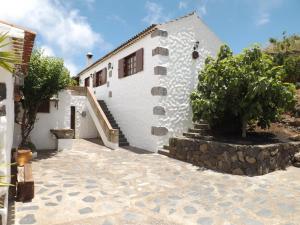 une maison blanche avec une passerelle en pierre devant elle dans l'établissement Casa Rural La Cuna, à Los Silos