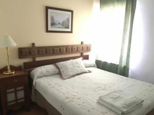 a bedroom with a bed and a lamp and a window at Rincón de Torres VT7250 in Valdelaguna