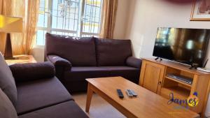 a living room with a couch and a flat screen tv at Playa Golf Quad House with Communal Pool Calle Castillo de San Roque P231 in Orihuela