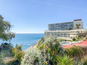 a building on a hill next to the ocean at Apartamento moderno con vistas panorámicas in Torremolinos