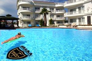a person swimming in a pool in front of a hotel at BELKA GOLF RESİDENCE Luxury Apt Poolside Belek in Belek