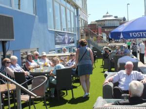 a group of people sitting at tables on the grass at Royal Seabank Hotel in Blackpool