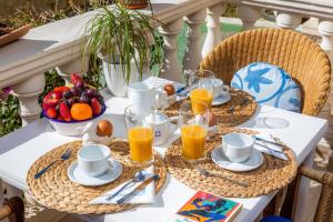 a table with a breakfast of fruit and orange juice at Can Nogueras in Cala Ratjada