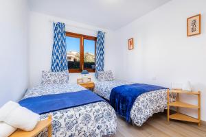 a bedroom with two beds and a window at Can Nogueras in Cala Ratjada +17 photos