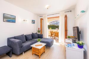 a living room with a blue couch and a tv at Can Nogueras in Cala Ratjada