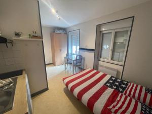 a room with a bed with an american flag blanket at Studio agréable et lumineux in Niort