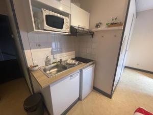 a small kitchen with a sink and a microwave at Studio agréable et lumineux in Niort