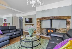 a living room with a couch and a fireplace at Maltings House in Milton Abbas