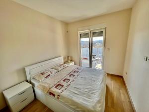 - une chambre avec un grand lit et un balcon dans l'établissement Fanky City Apartments, à Podgorica