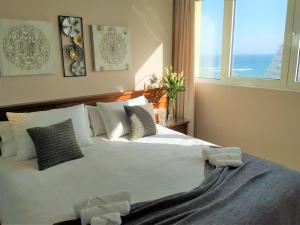 Un dormitorio con una cama blanca con almohadas y una ventana en New 2023 Don Gustavo, Beach Front, Sea Views, en Benalmádena