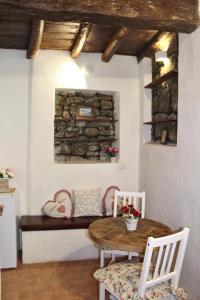 einen Tisch und Stühle in einem Zimmer mit einer Steinmauer in der Unterkunft Torre Iolanda in Campagnano di Roma