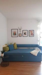 a blue couch in a living room with pictures on the wall at Apartment Tauernblick in Ramsau am Dachstein