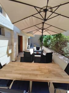 patio con tavolo in legno e ombrellone di Le THIERS-TEMPS - AC CLIM - GRANDE TERRASSE - PROCHE THEATRES ad Avignone Altre 25 foto