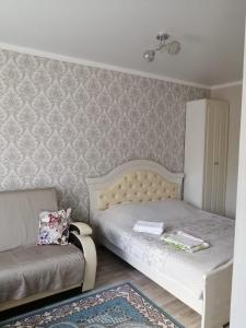 a small bedroom with a bed and a chair at Happy House in Karagandy