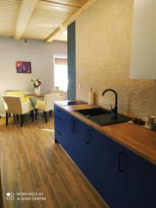 a kitchen with a sink and a table with chairs at Apartamenty Golden Village in Duszniki Zdrój