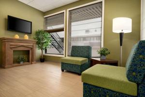 ハーストにあるSuper 8 by Wyndham Hearst ONの暖炉と椅子のある待合室のあるロビー