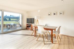 een eetkamer met een tafel en witte stoelen bij Grüntrach in Sonthofen +1 foto
