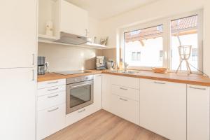 een witte keuken met witte kasten en een raam bij Grüntrach in Sonthofen