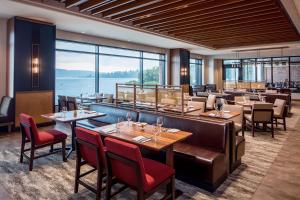 a restaurant with tables and chairs and a large window at Hyatt Regency Lake Washington at Seattle's Southport in Renton