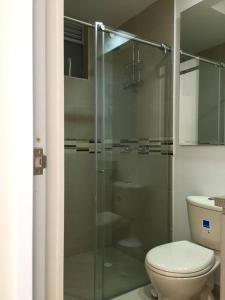 a bathroom with a toilet and a glass shower at HERMOSO APARTAMENTO EN GIRARDOT CON AIRE ACONDICIONADO in Girardot