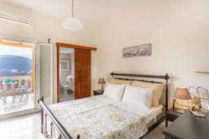 a bedroom with a bed and a balcony at Traditional House @ Chora Astypalea in Astypalaia Town