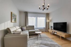 a living room with a couch and a flat screen tv at Angel Boutique Home - Entire premium house in Laško +35 photos