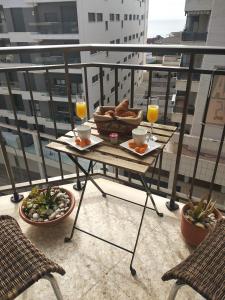 a table on a balcony with two glasses of orange juice at Calpe Star in Calpe