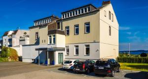 two cars parked in front of a building at Hotel Kieler Förde & Free Parking in Kiel