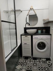 uma casa de banho com uma máquina de lavar roupa e um espelho. em Villa dans résidence privée au bord du lac d'Hourtin port em Hourtin