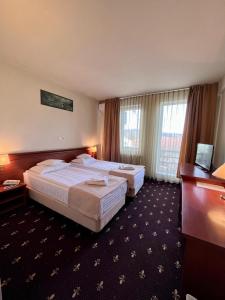 a hotel room with two beds and a window at Hotel Seven in Cluj-Napoca