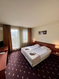 a hotel room with a bed and a television at Hotel Seven in Cluj-Napoca