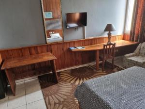 Cette chambre comprend un bureau et un miroir. dans l'établissement HOTEL SAFFANA, à Douala