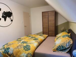 um quarto com uma cama com lençóis amarelos e azuis em De Gorzen em Oud-Turnhout