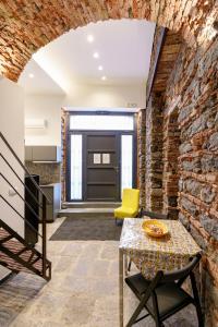 a brick hallway with a table and a yellow chair at Antico Basolato House in Catania