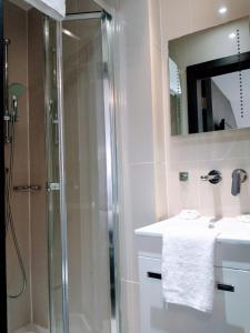 un baño con ducha y lavabo en Hotel Edward Paddington, en Londres 72 fotos más