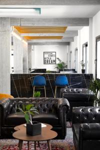 a lobby with black leather furniture and blue chairs at Play Theatrou Athens in Athens