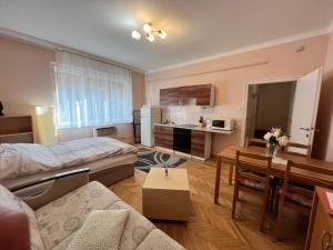 sala de estar con cama y cocina en Révay Apartment en Szeged