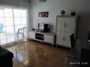 a living room with a tv and a entertainment center at MOJACAR PLAYA in Mojácar