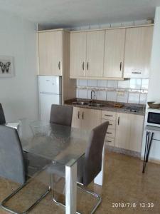 a kitchen with a glass table and white cabinets at MOJACAR PLAYA in Mojácar