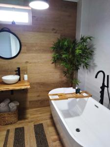 un bagno con una grande vasca bianca e una pianta di Piso grande con terraza a Fisterra (Finisterre)