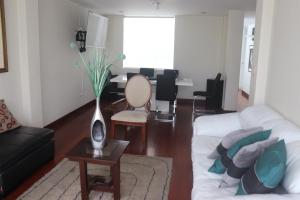 een woonkamer met een witte bank en een tafel bij Cayma Apart's II in Arequipa