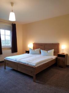 a bedroom with a large wooden bed with two pillows at Ritterhof Kampehl in Neustadt