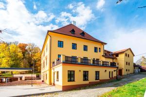 a yellow building with a balcony on the side of it at Vila Lovců králových in Český Krumlov