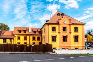 ein gelbes Gebäude mit einer Uhr darüber in der Unterkunft Vila Lovců králových in Český Krumlov
