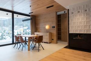 a dining room with a table and chairs and a fireplace at udanypobyt Apartament LUXURY Strążyska 31 in Zakopane
